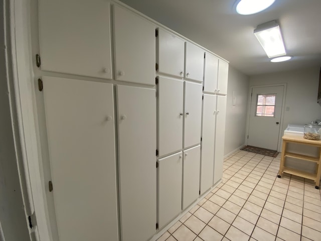 kitchen featuring light tile patterned flooring and white cabinets