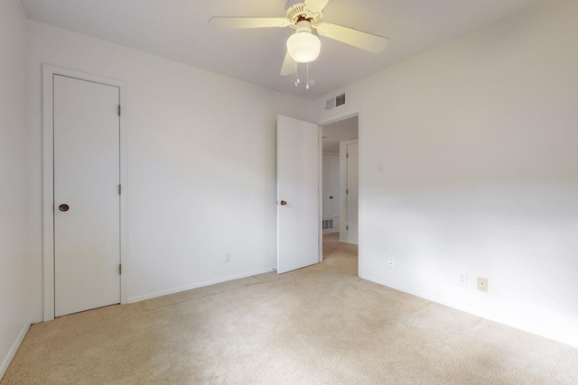 unfurnished room featuring light carpet, visible vents, and ceiling fan