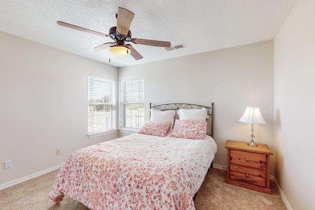 bedroom featuring baseboards, visible vents, ceiling fan, a textured ceiling, and carpet flooring