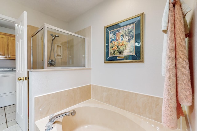 bathroom featuring tile patterned floors, washer / clothes dryer, a stall shower, and a bath