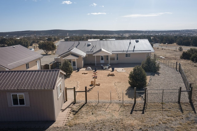 rear view of property featuring fence and metal roof