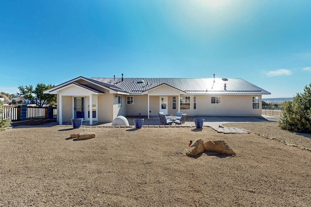 rear view of property featuring a patio area, stucco siding, french doors, and fence