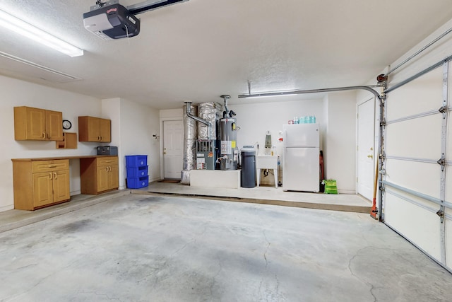 garage featuring a sink, a garage door opener, water heater, and freestanding refrigerator