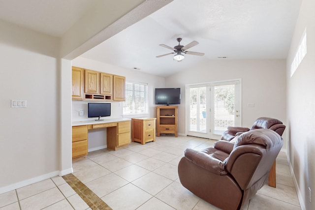 living area with baseboards, vaulted ceiling, light tile patterned floors, built in study area, and a ceiling fan