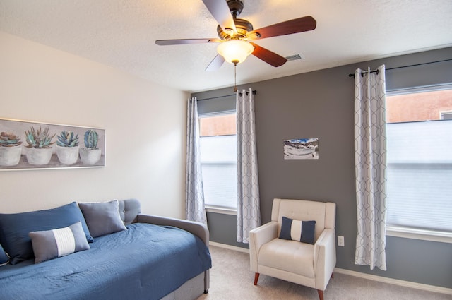 carpeted bedroom featuring visible vents, baseboards, a textured ceiling, and ceiling fan