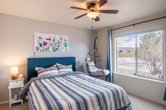 carpeted bedroom featuring multiple windows, baseboards, and ceiling fan