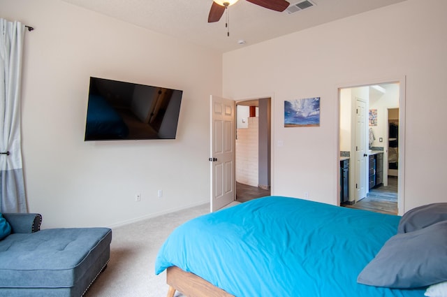 bedroom featuring visible vents, a ceiling fan, ensuite bath, carpet, and baseboards