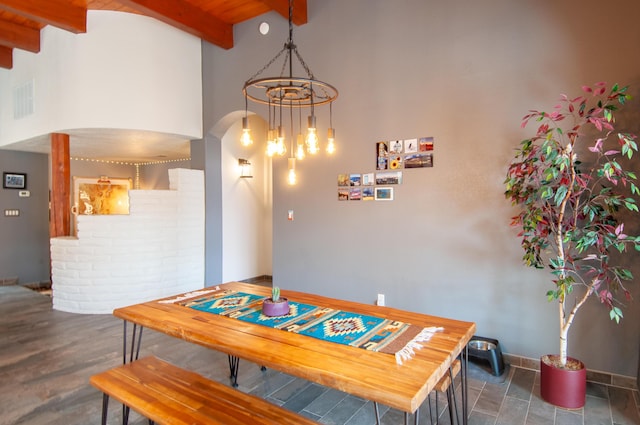 dining space featuring visible vents, beamed ceiling, arched walkways, an inviting chandelier, and baseboards