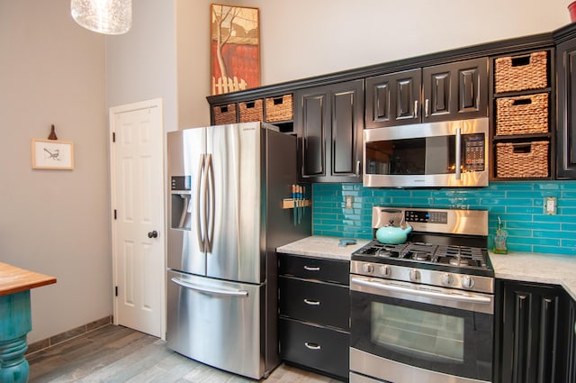 kitchen featuring tasteful backsplash, stainless steel appliances, light wood-type flooring, and light stone countertops