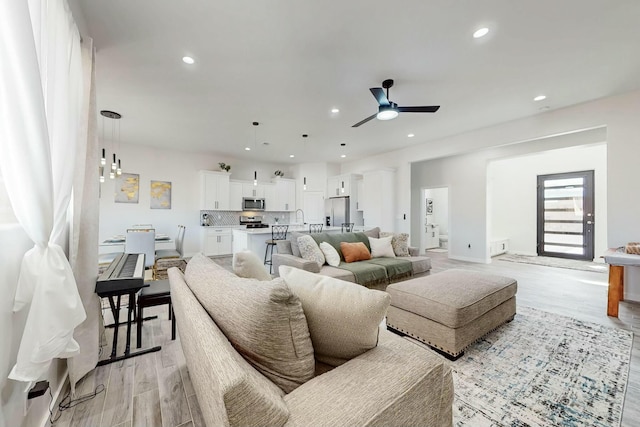 living room featuring recessed lighting, light wood-style floors, and ceiling fan