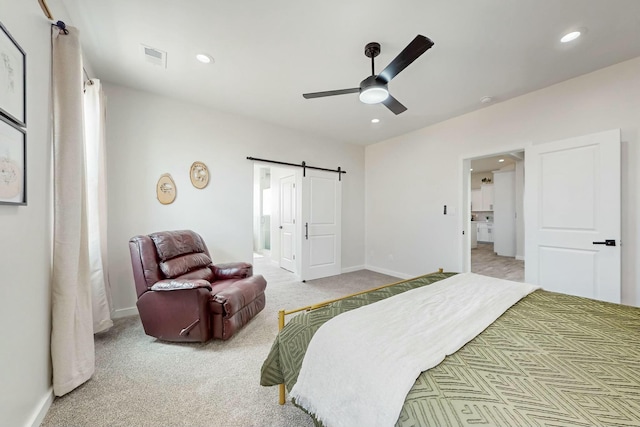 carpeted bedroom with visible vents, ensuite bathroom, recessed lighting, a barn door, and baseboards