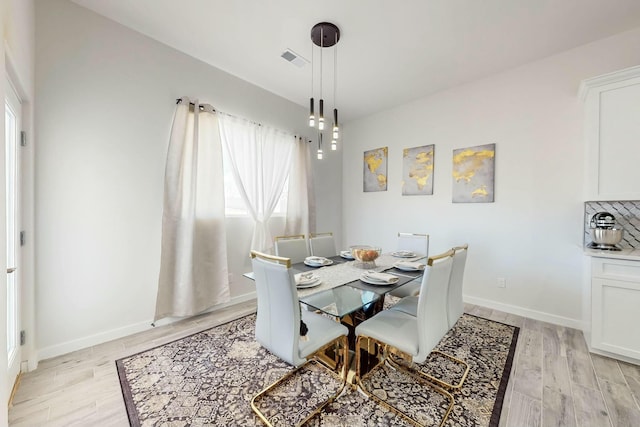 dining room with light wood-style flooring, baseboards, and visible vents