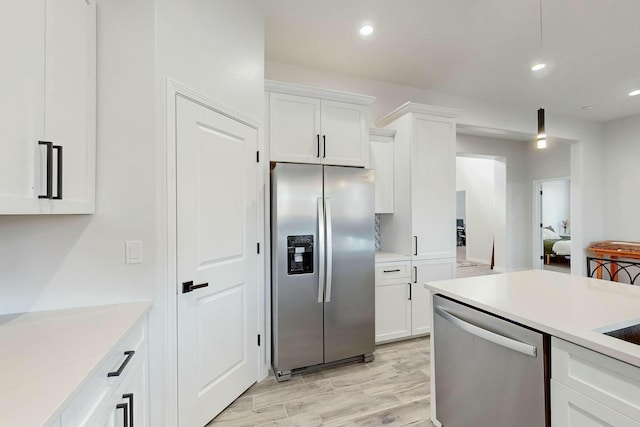 kitchen with light wood-style flooring, white cabinetry, recessed lighting, appliances with stainless steel finishes, and light countertops