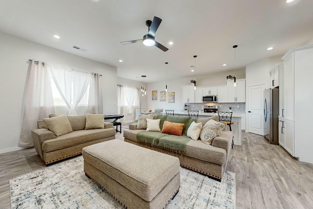 living room with light wood finished floors, visible vents, recessed lighting, and a ceiling fan