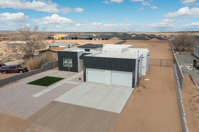 view of front of home featuring fence, a residential view, stucco siding, a garage, and driveway