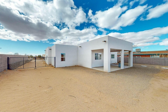 rear view of house with a patio, fence private yard, and stucco siding