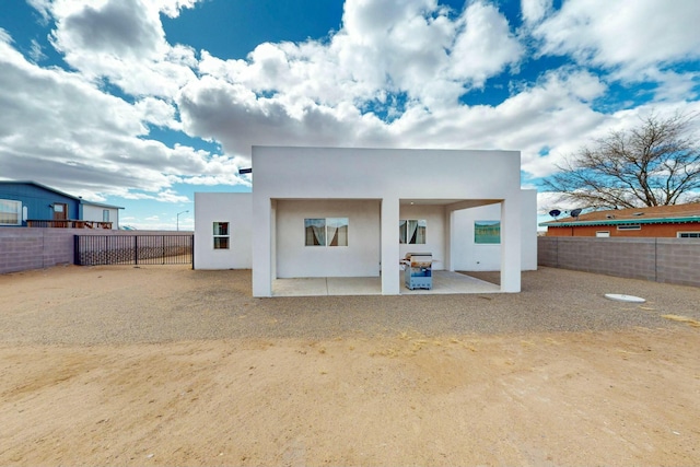 rear view of property with a fenced backyard, stucco siding, and a patio