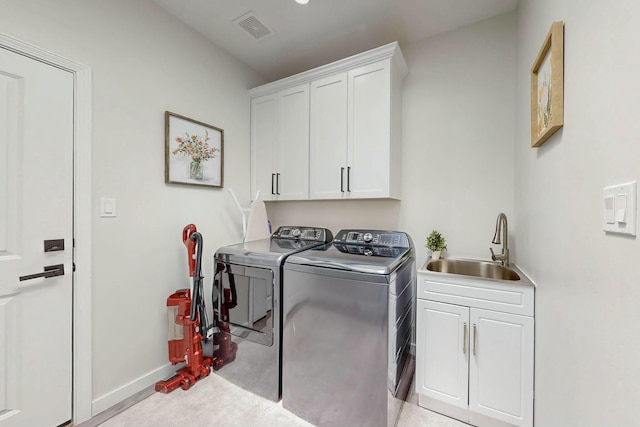 laundry room featuring visible vents, a sink, cabinet space, baseboards, and washing machine and clothes dryer