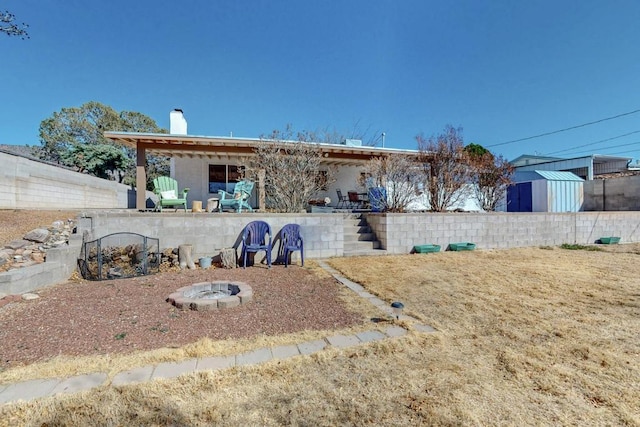 view of yard with a patio area, a fire pit, a storage shed, and an outdoor structure