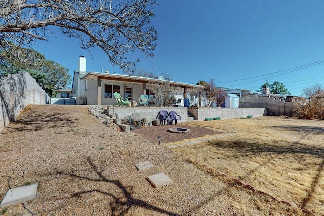 rear view of house with a patio, a chimney, and fence