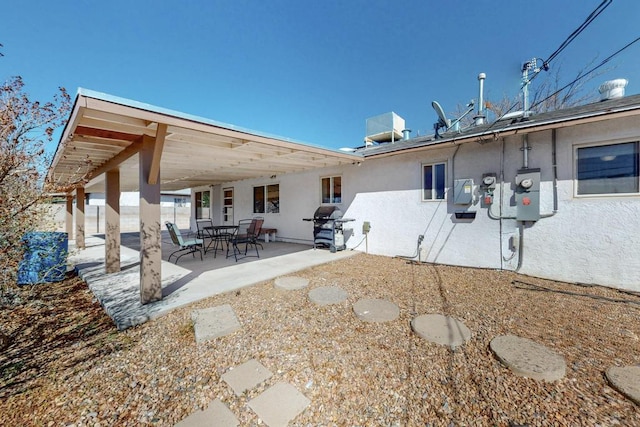 rear view of property featuring a patio area, central AC, and stucco siding