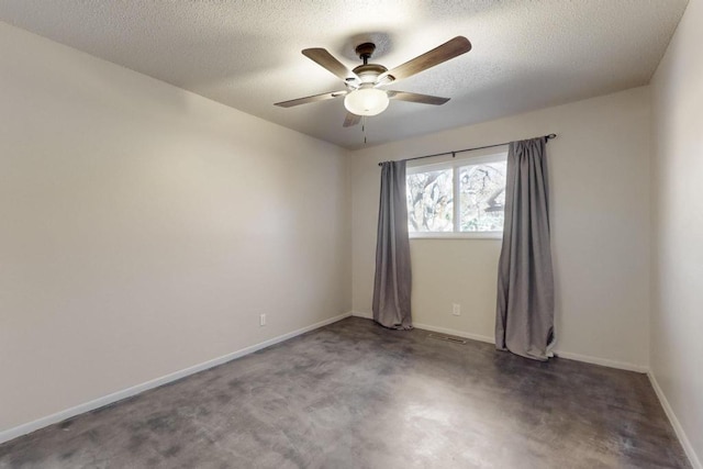 spare room featuring baseboards, visible vents, a textured ceiling, and ceiling fan