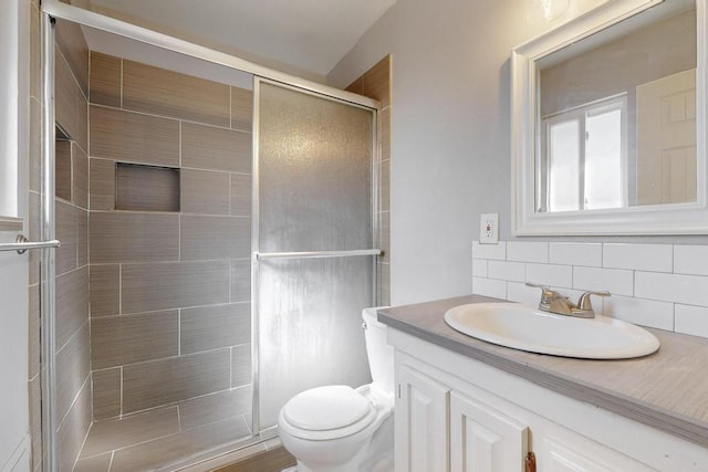 full bathroom featuring backsplash, a shower stall, toilet, and vanity