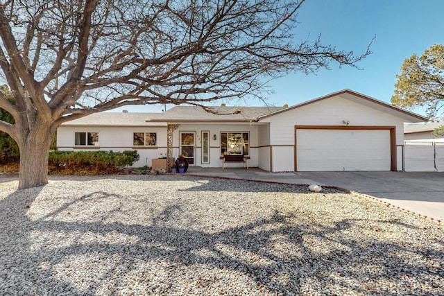 ranch-style house featuring covered porch, an attached garage, and driveway