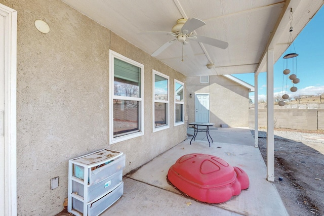 view of patio featuring a ceiling fan and fence