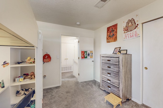 bedroom featuring visible vents, carpet floors, and a textured ceiling