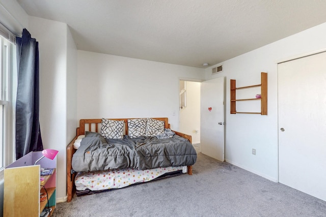 bedroom with carpet, visible vents, and baseboards