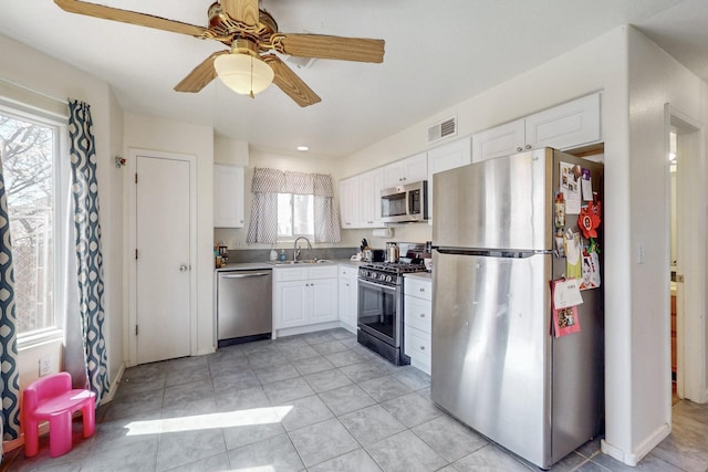 kitchen featuring a sink, white cabinets, visible vents, and stainless steel appliances