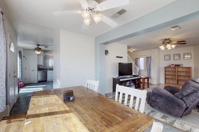 dining room featuring stairs, visible vents, and a ceiling fan