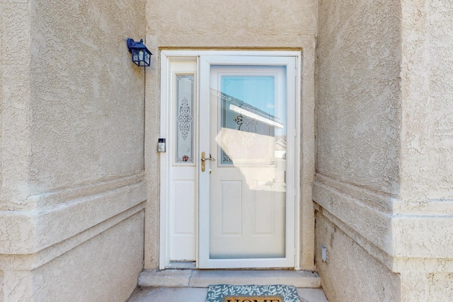 property entrance with stucco siding