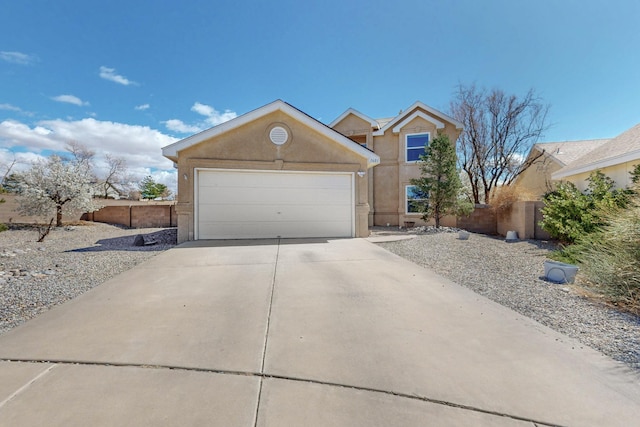 view of front of property with stucco siding, driveway, an attached garage, and fence