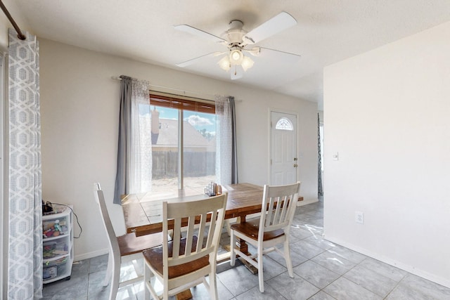 dining room with light tile patterned flooring, baseboards, and ceiling fan