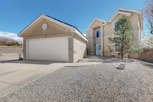 view of front of property with an outbuilding, a garage, driveway, and stucco siding