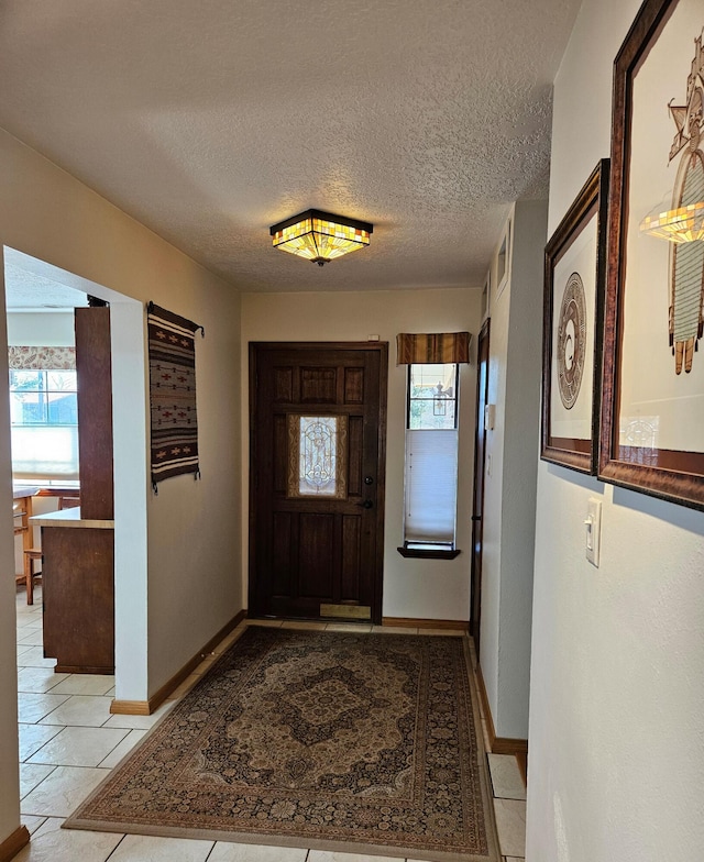 foyer entrance with a textured ceiling and baseboards