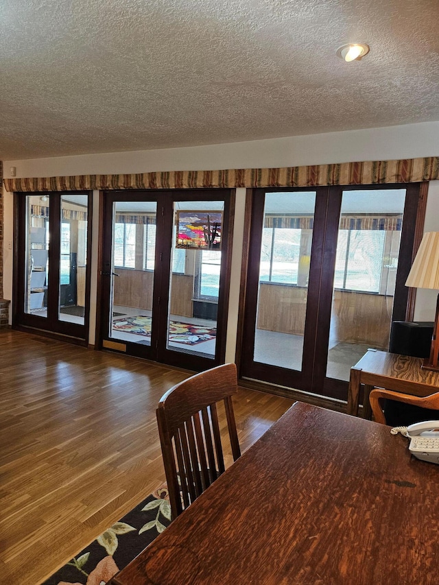 unfurnished dining area with a textured ceiling and dark wood-type flooring