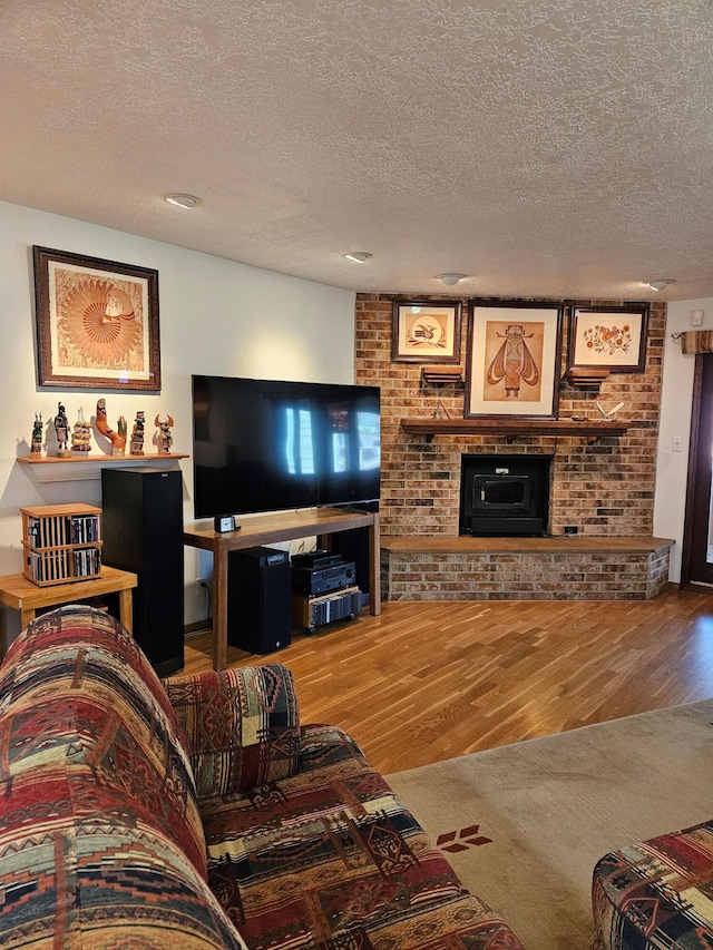 living area with a textured ceiling, wood finished floors, and a fireplace