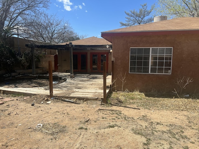 back of house featuring a shingled roof, central AC, stucco siding, french doors, and a patio area