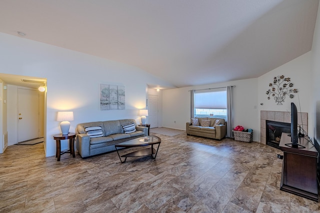 living area featuring lofted ceiling and a tile fireplace