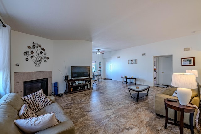 living area featuring visible vents, ceiling fan, and a tile fireplace