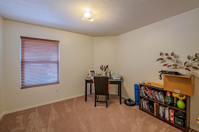 carpeted office with baseboards and a textured ceiling