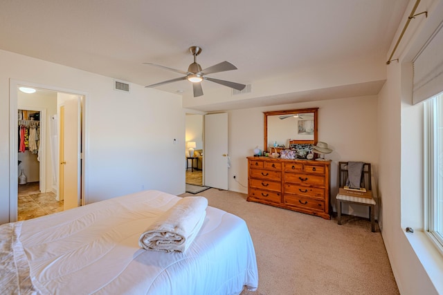 bedroom featuring ceiling fan, visible vents, and light carpet