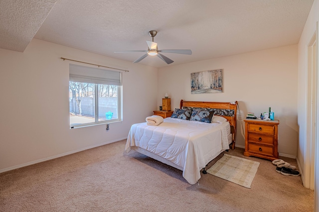 carpeted bedroom with baseboards, a textured ceiling, and a ceiling fan