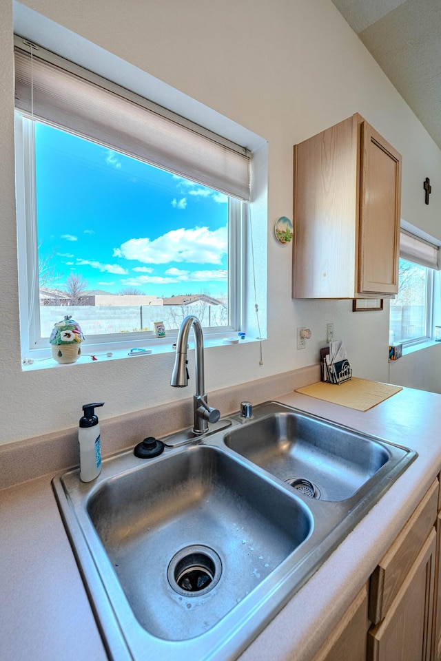 kitchen featuring light countertops, light brown cabinets, and a sink