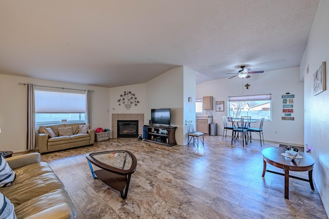 living room with a fireplace, a textured ceiling, lofted ceiling, and a ceiling fan