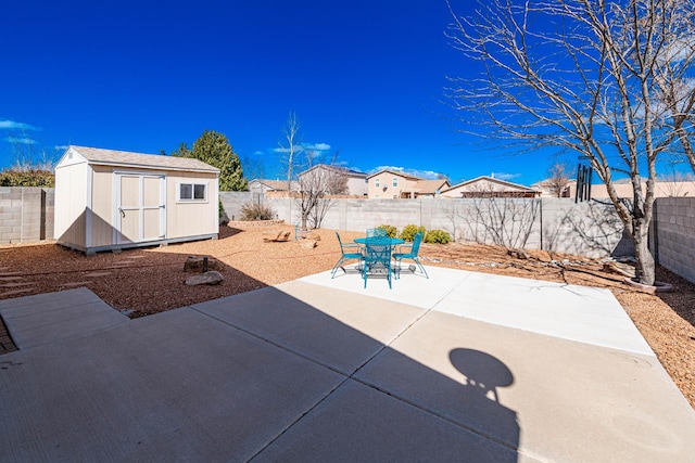 view of patio featuring an outbuilding, a fenced backyard, and a shed