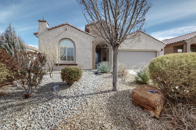 view of front of house with stucco siding, an attached garage, and a tile roof